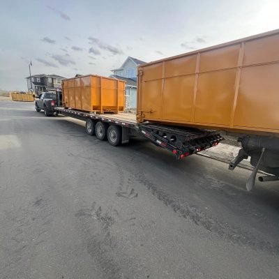 Equi-Waste Services Ltd multiple yellow dumpster bins at urban commercial construction site with workers